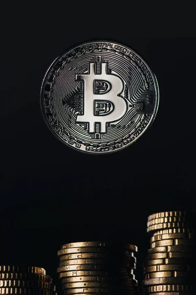 Vista de perto de prata bitcoin e pilhas de centavos isolados em preto — Fotografia de Stock