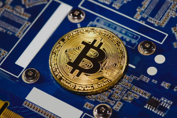 Close up view of golden bitcoin on computer motherboard — Stock Photo