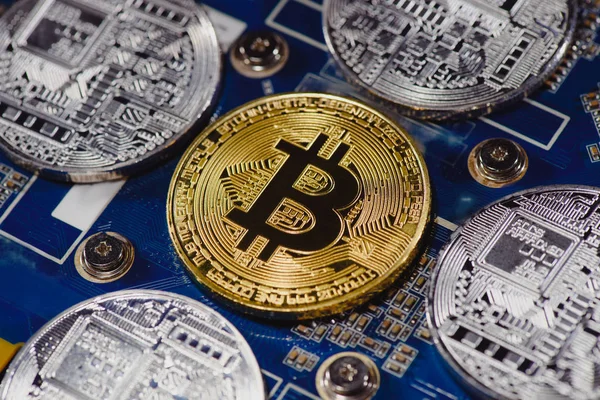 Vue rapprochée des bitcoins dorés et argentés disposés sur la carte mère de l'ordinateur — Photo de stock