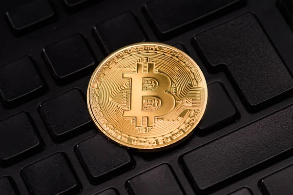 Close up view of golden bitcoin in black keyboard — Stock Photo