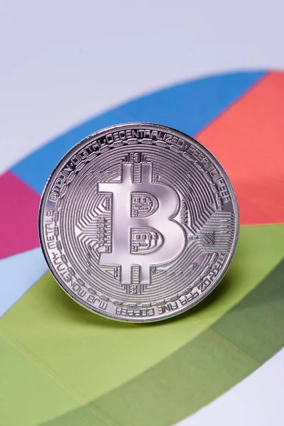 Close up view of silver bitcoin on colorful diagram — Stock Photo