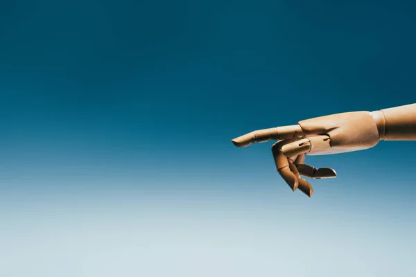 Close up view of wooden puppet hand on blue backdrop — Stock Photo