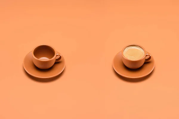 Vue rapprochée de tasse vide et tasse de café isolé sur la pêche — Photo de stock