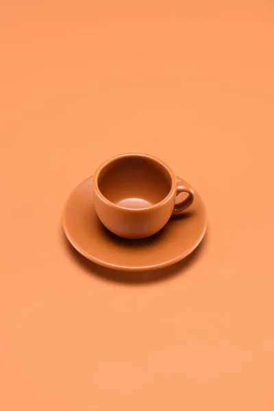 Close up view of empty cup on saucer isolated on peach — Stock Photo