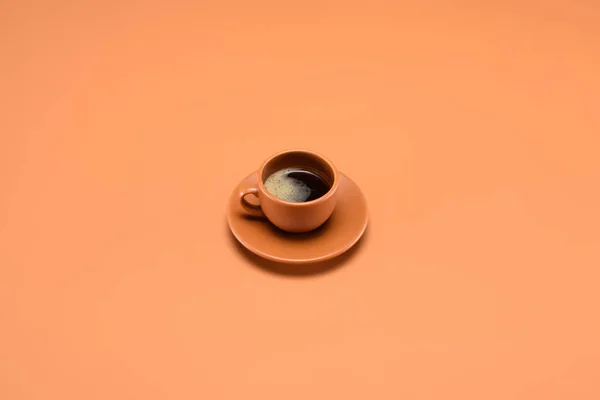 Primer plano vista de la taza de café en platillo aislado en melocotón - foto de stock