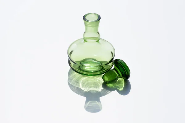 Close up view of empty glass bottle and cork on white backdrop — Stock Photo