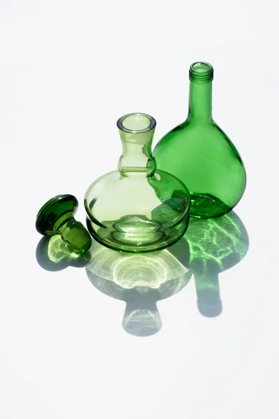 Close up view of empty glass bottles and cork on white backdrop — Stock Photo