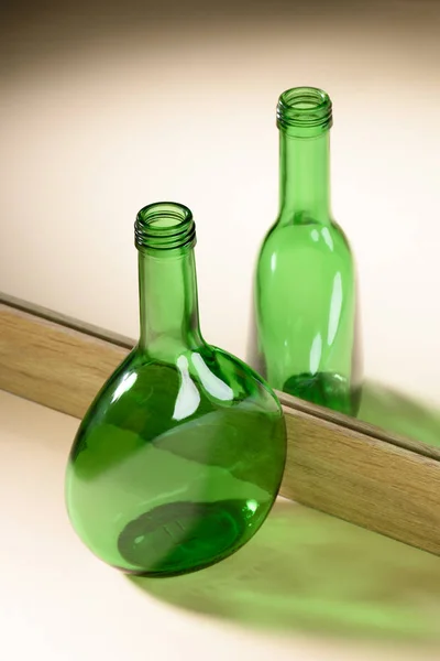 Vista de cerca de la reflexión botella de vidrio verde en el espejo - foto de stock