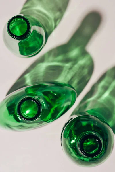 Top view of green empty glass bottles arranged on white tabletop — Stock Photo