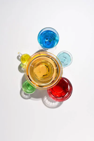 Flat lay with various alcohol cocktails in glasses on white backdrop — Stock Photo