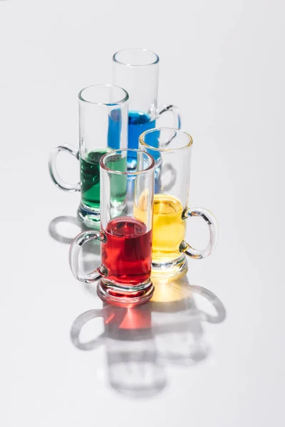 Vista de perto de coquetéis de álcool organizados em óculos no fundo branco — Fotografia de Stock