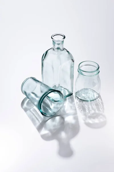 Close up view of empty glassware and shadows on white surface — Stock Photo