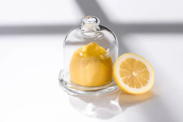Close up view of fresh lemon in glassware on white tabletop — Stock Photo
