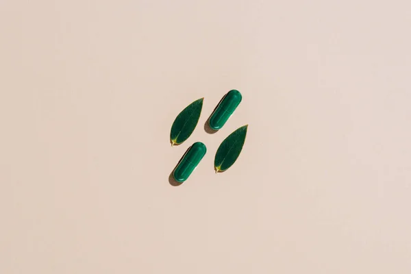 Ansicht von Phytotherapie-Pillen und Blättern auf beiger Oberfläche — Stockfoto