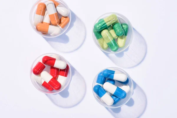 Top view of various colorful pills in plastic cans on white — Stock Photo