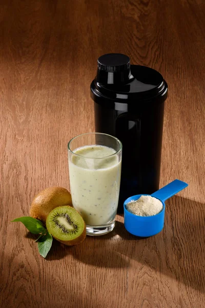Close-up shot of protein shake with kiwi on wooden surface — Stock Photo