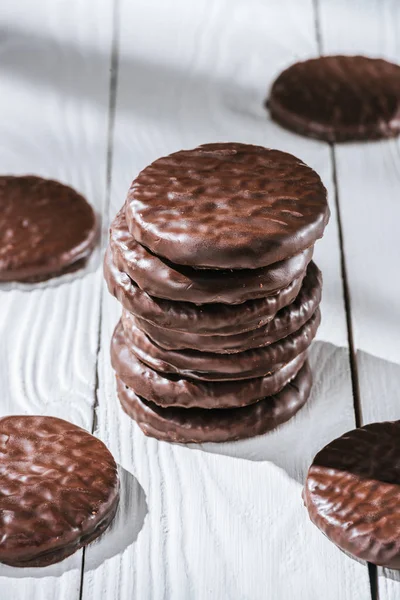 Gros plan de la pile de délicieux biscuits au chocolat glacé sur une table en bois blanc — Photo de stock