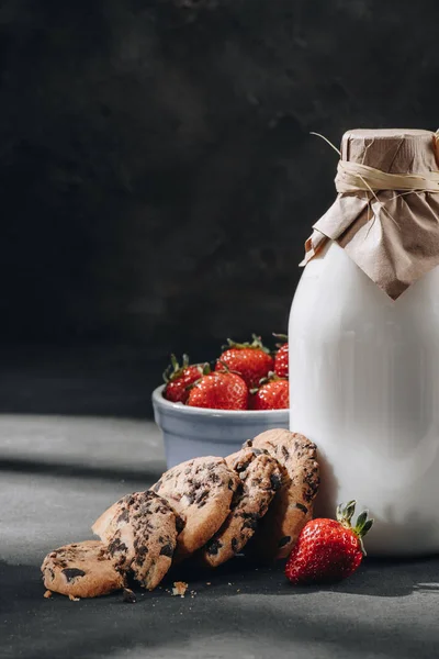 Nahaufnahme von leckeren Schokoladenkeksen mit Milch und Erdbeeren — Stockfoto
