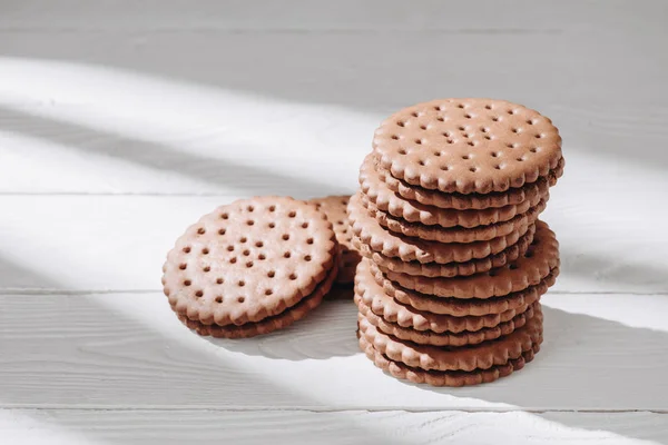 Primer plano de deliciosas galletas de chocolate sobre mesa de madera blanca - foto de stock