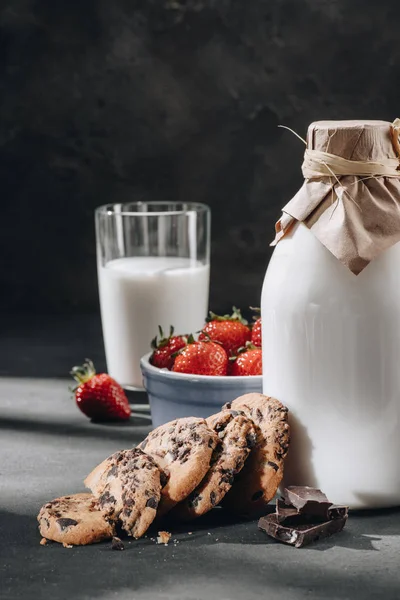 Close-up shot of chocolate-chip cookies with milk and strawberries — Stock Photo