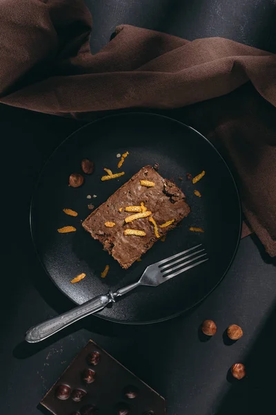 Top view of delicious chocolate cake with orange zest on black plate — Stock Photo