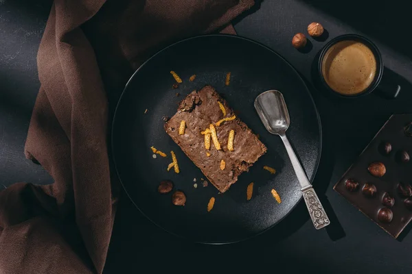 Schokoladenkuchen mit Orangenschale auf schwarzem Teller — Stockfoto
