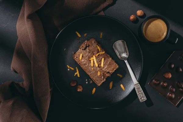 Vista superior do bolo de chocolate com raspas de laranja na placa preta — Fotografia de Stock