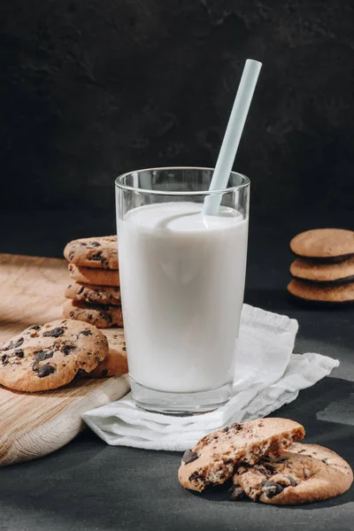 Nahaufnahme eines Glases Milch mit leckeren Schokolade-Chips-Keksen — Stockfoto