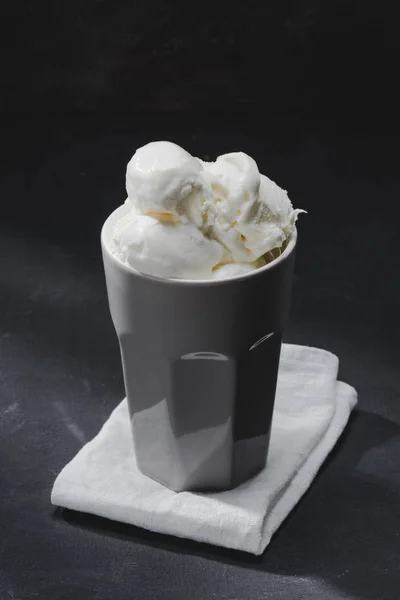 Delicious ice cream in cup on napkin on table — Stock Photo