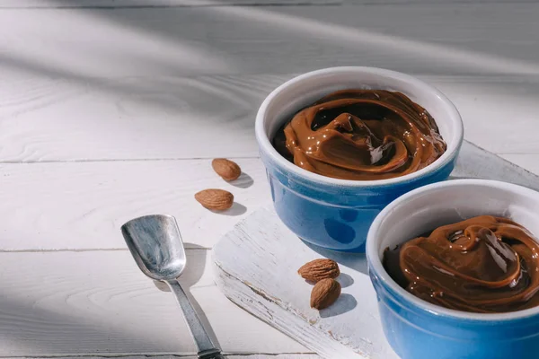 Bowls with chocolate dessert on wooden board on table — Stock Photo