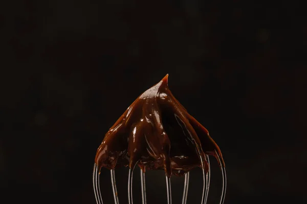 Gustoso cioccolato su frusta isolato su nero — Foto stock