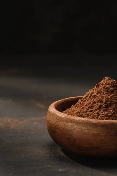 Обрізане зображення порошку какао в дерев'яній мисці на столі — стокове фото