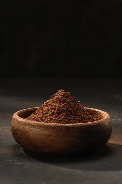 Poudre de cacao dans un bol en bois sur la table — Photo de stock