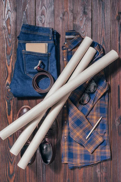 Flat lay com camisa masculina, sapatos, jeans, óculos e plantas arquitetônicas dispostas na superfície de madeira — Fotografia de Stock