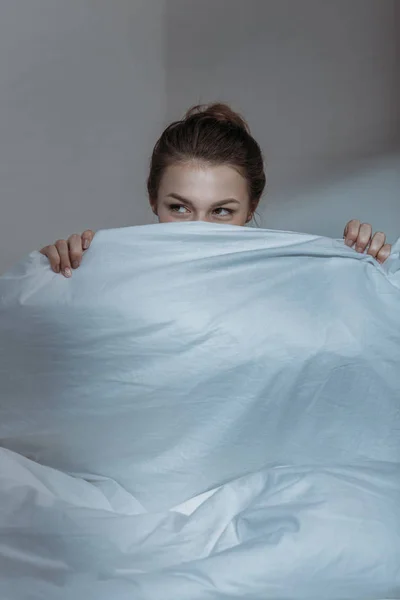 Mulher cobrindo rosto com colcha — Fotografia de Stock