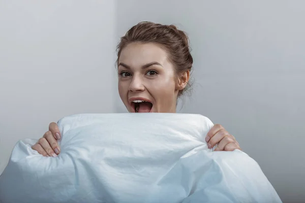 Gezicht van de bekleding van de vrouw met bedcover — Stockfoto