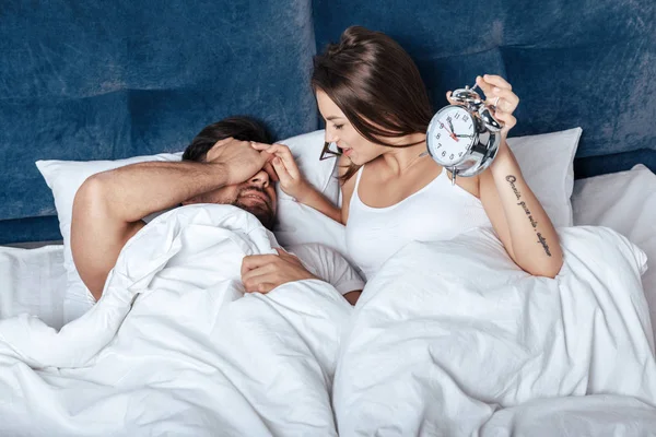 Paar met wekker wakker — Stockfoto