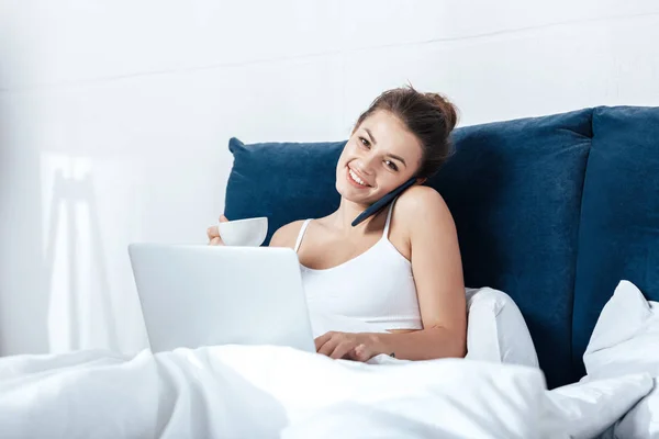 Vrouw werkt op laptop in bed — Stockfoto