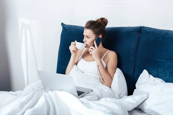 Vrouw werkt op laptop in bed — Stockfoto