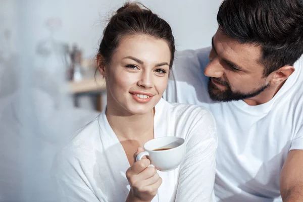 Ung kvinna har kaffe i sängen — Stockfoto