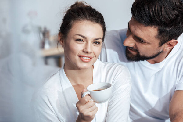 young woman having coffee in bed