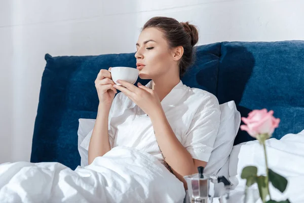Kvinna med kaffe i sängen — Stockfoto
