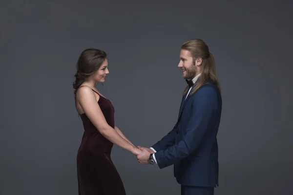 Sweethearts in evening outfit holding hands — Stock Photo, Image