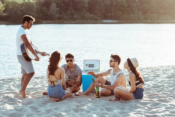 Vrienden drinken bier op strand — Stockfoto