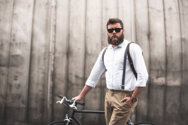 stylish man standing with bicycle clipart