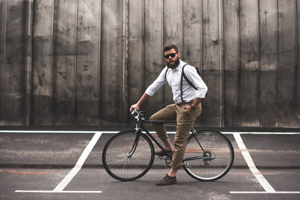 стильный мужчина, сидящий на велосипеде
