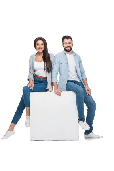 Couple sitting on cube — Stock Photo, Image