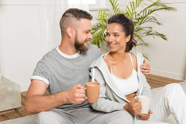 Ζευγάρι πίνοντας καφέ ενώ κάθεται στο σπίτι — Φωτογραφία Αρχείου