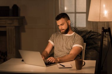 Dalgın adam üstünde laptop evde çalışma