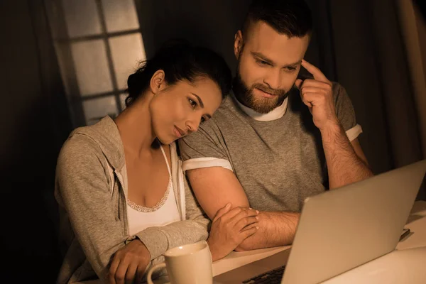 Молодая задумчивая пара смотрит на ноутбук — стоковое фото